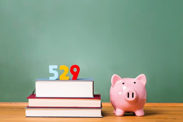 529 college savings plan theme with textbooks and piggy bank