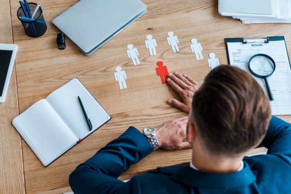 top view of man near paper human shapes on table