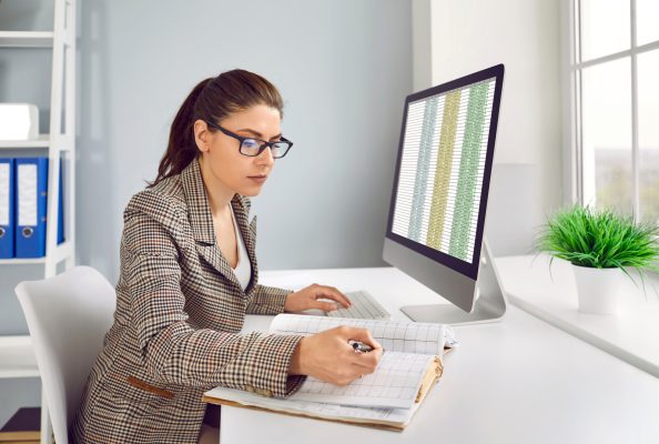 business accountant checking financial records and working with spreadsheets on computer