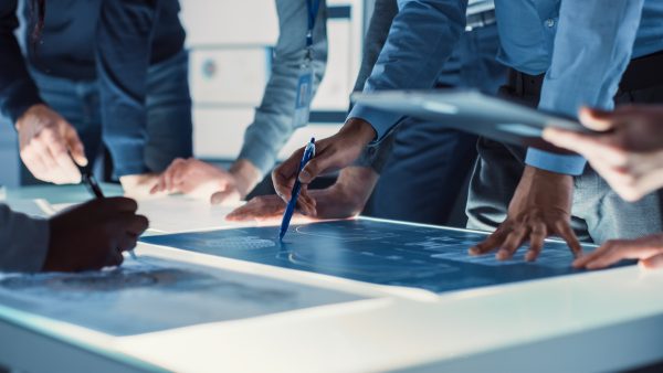 engineer, scientists and developers gathered around illuminated