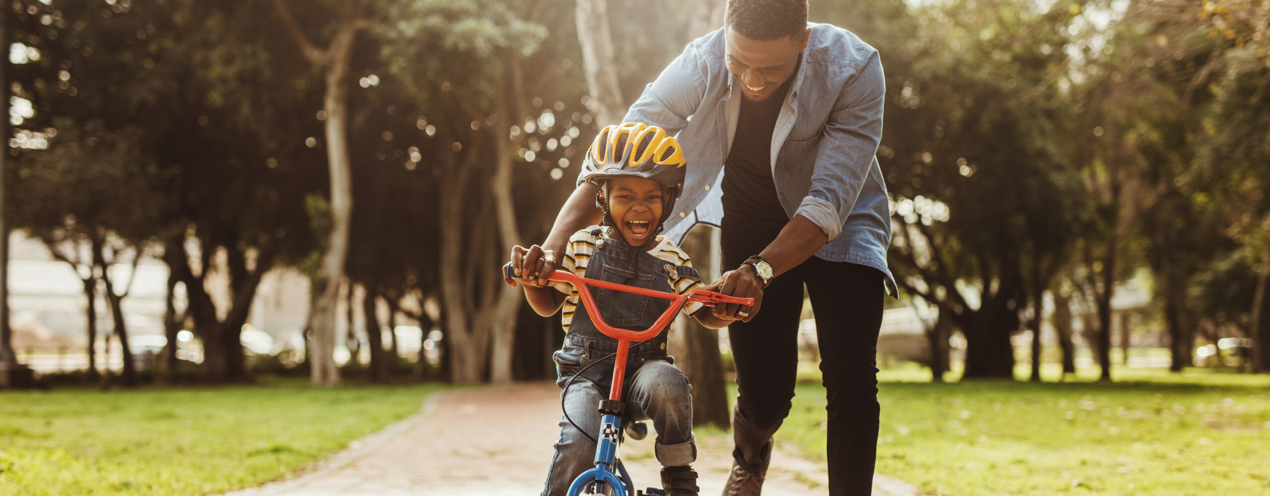 father teaching his son cycling at park