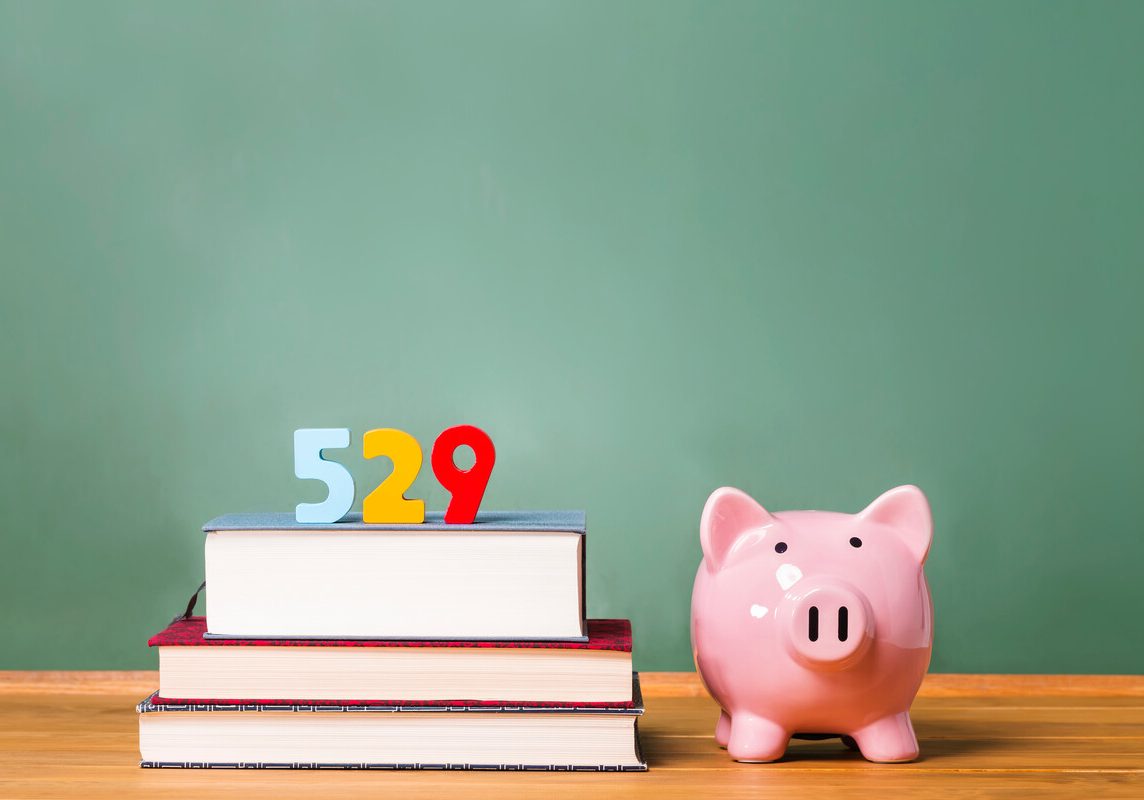 529 college savings plan theme with textbooks and piggy bank