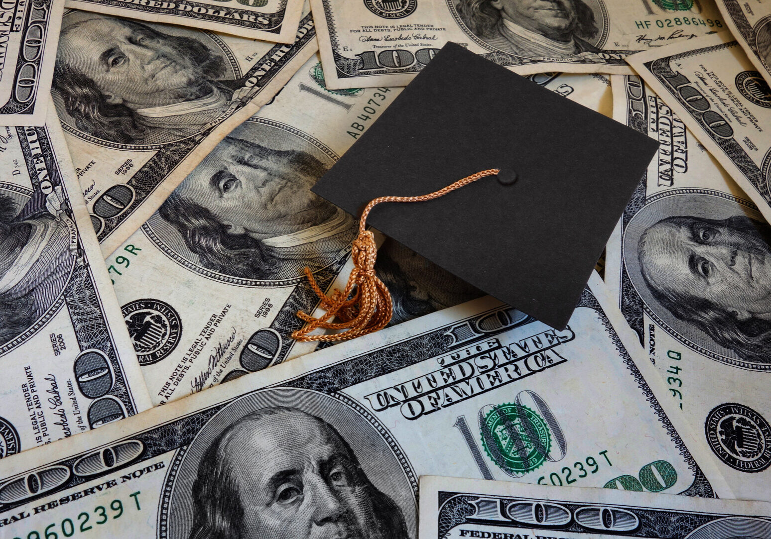 graduation cap on money