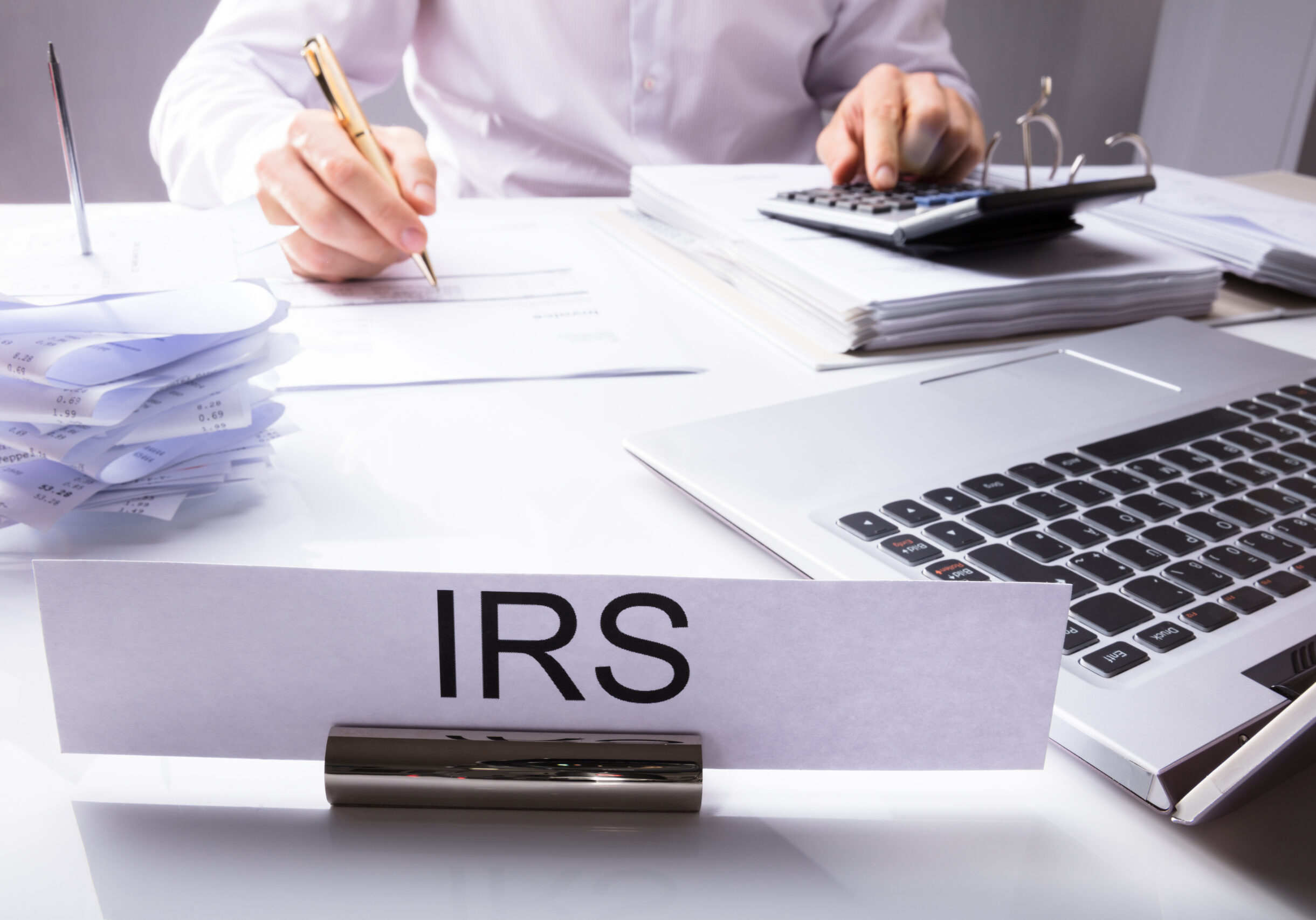 irs nameplate in front of accountant calculating tax