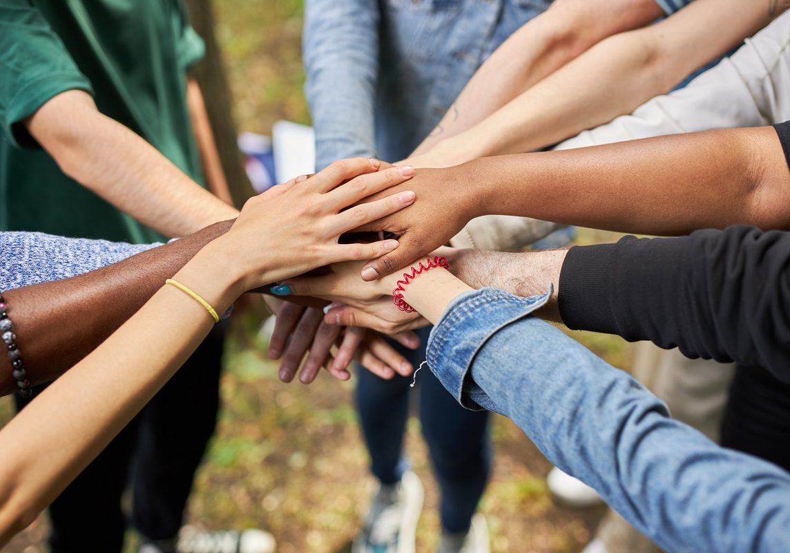 close up photo of diverse people's hands gathered together