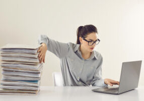 accountant no more needs piles of papers and is working with electronic documents on laptop