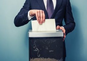 businessman shredding documents