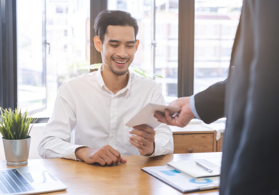 good job asian manager business man giving financial reward in an envelope, business letter extra salary to company employee, male worker office hand received premium bonus, getting cheque from boss.