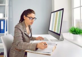 business accountant checking financial records and working with spreadsheets on computer
