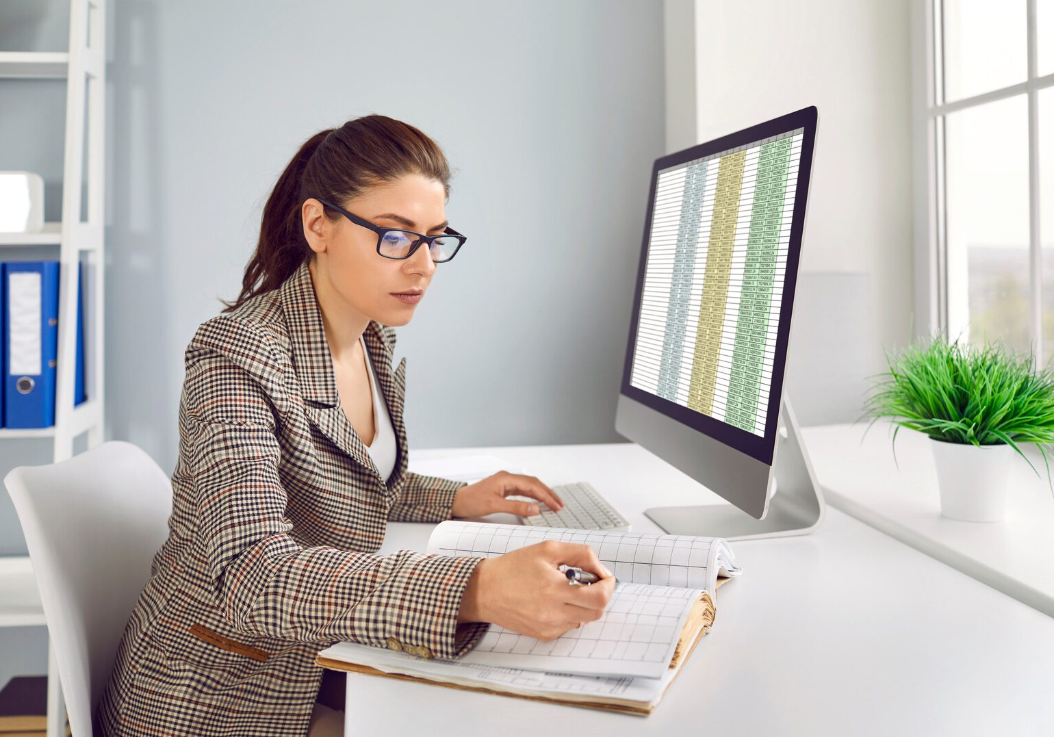 business accountant checking financial records and working with spreadsheets on computer