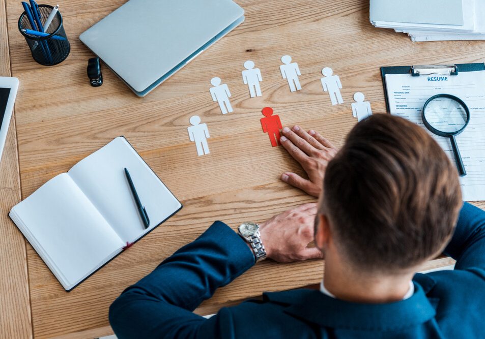 top view of man near paper human shapes on table